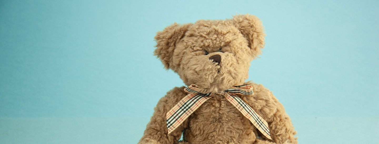 Lys Bamse Med Sløjfe Med Blå Baggrund